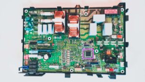 Carte électronique de pompe à chaleur DAIKIN sur laquelle le microntrôleur cassé est entouré par un carré rose. pour le mettre en évidence
